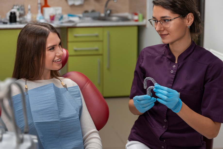 Dentist explaining the Invisalign Treatment process with clear aligners to a patient at Yonge Wellesley Dental in Toronto