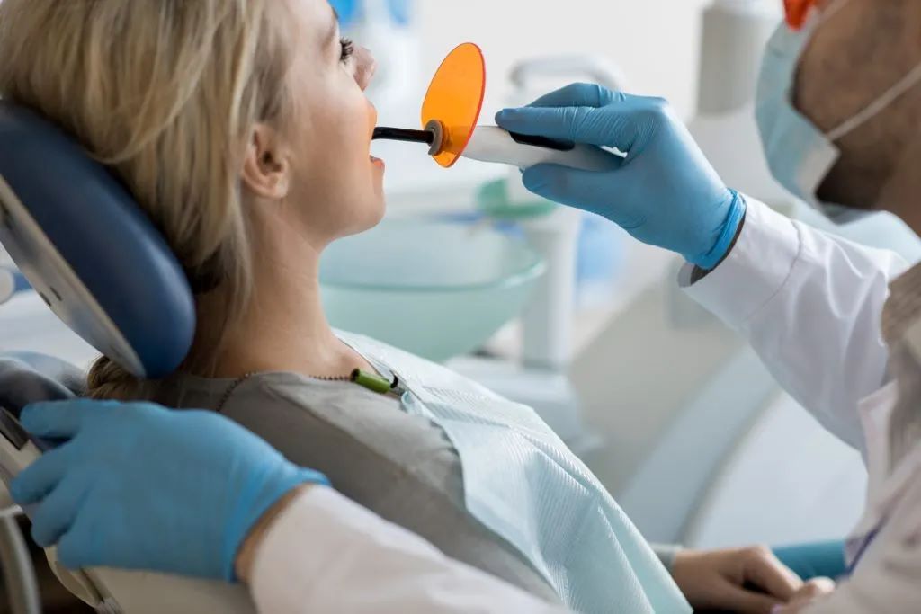 Tooth fillings composite curing procedure performed by a dentist at Yonge Wellesley Dental in Toronto